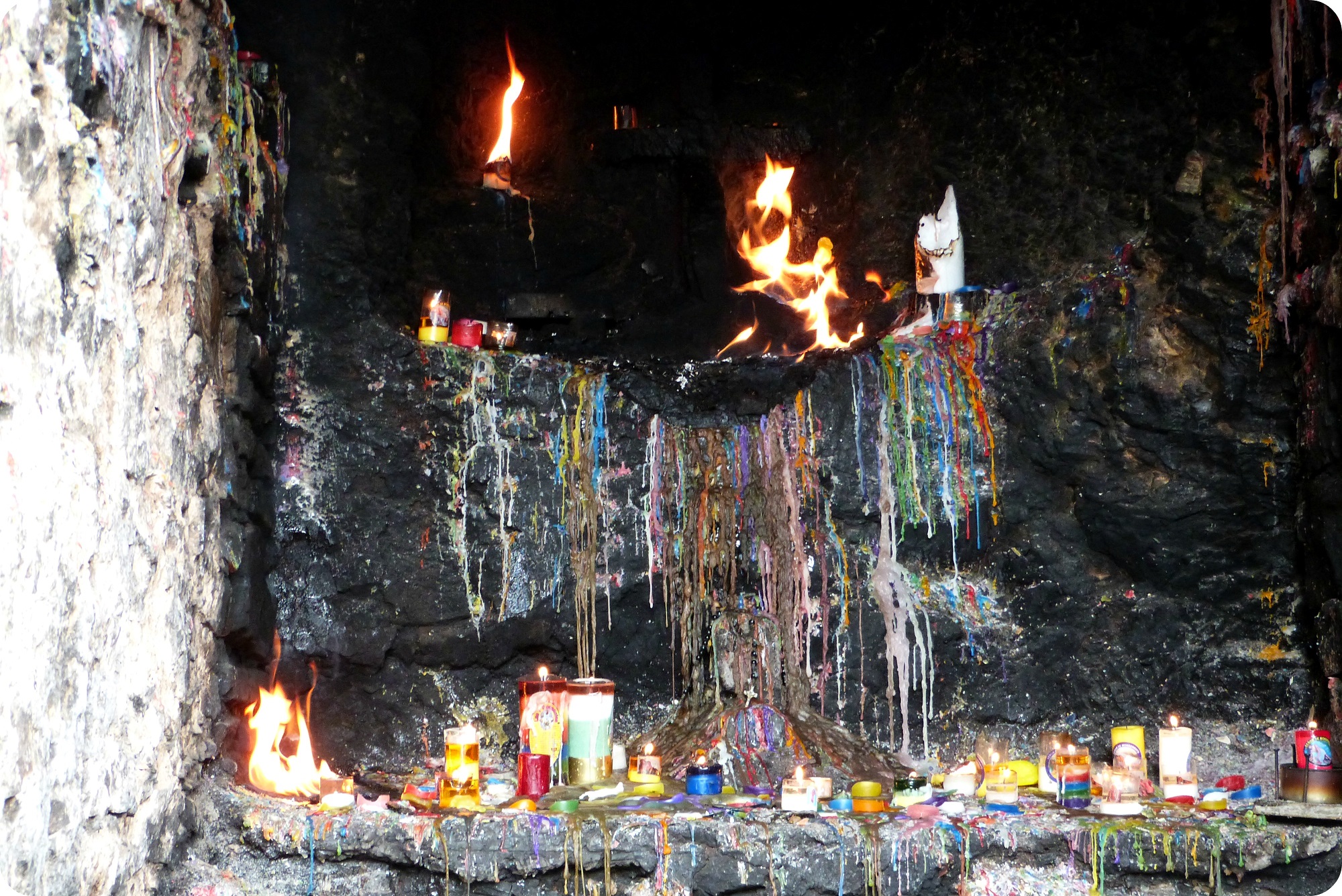 Bougies qui se consument laissant des traces de toutes les couleurs dans une cavité dans la montée vers Monserrate à Bogotá