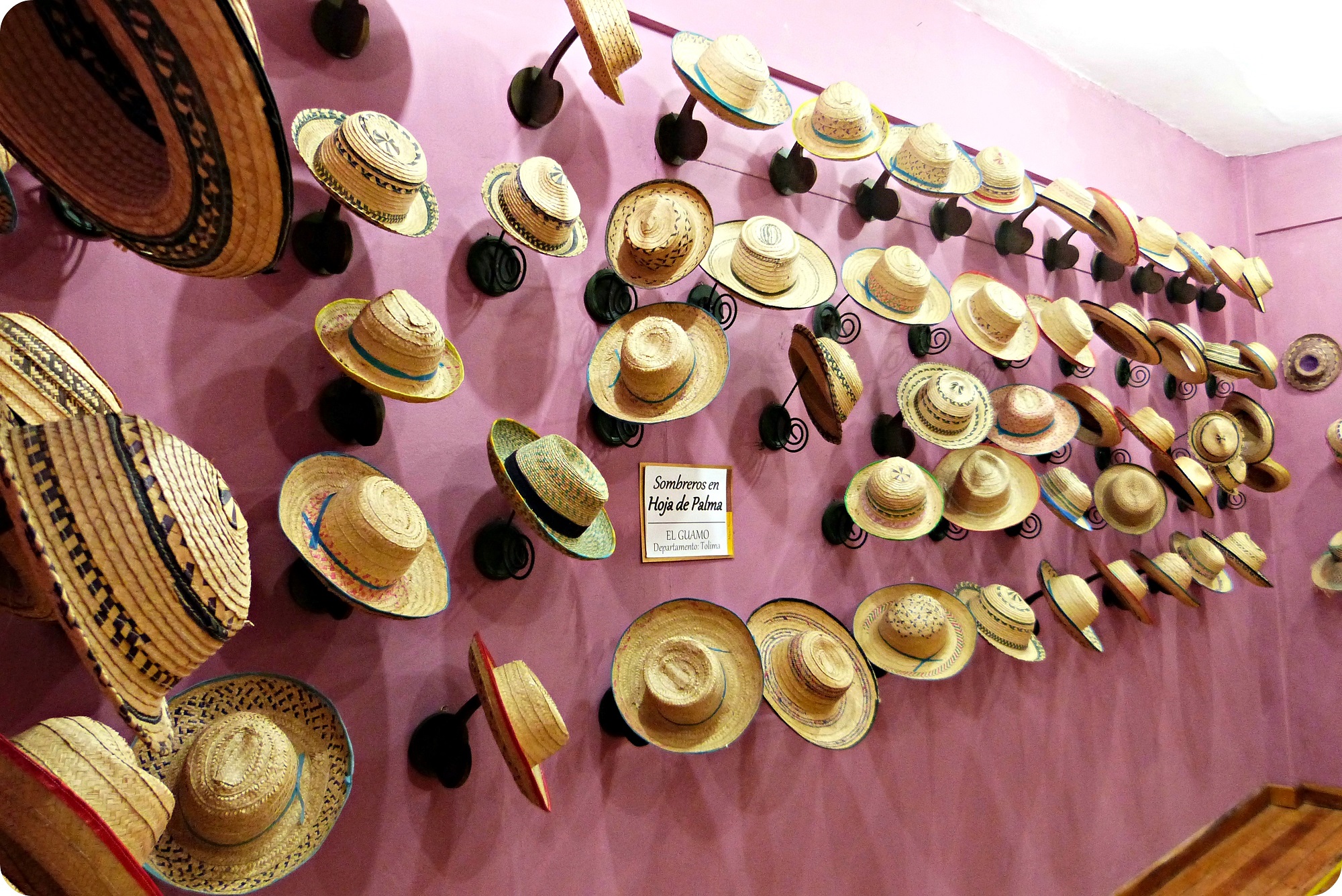 Sombreros expuestos en una pared morada, en el museo nacional del sombrero en la casa de la cultura en Aguadas