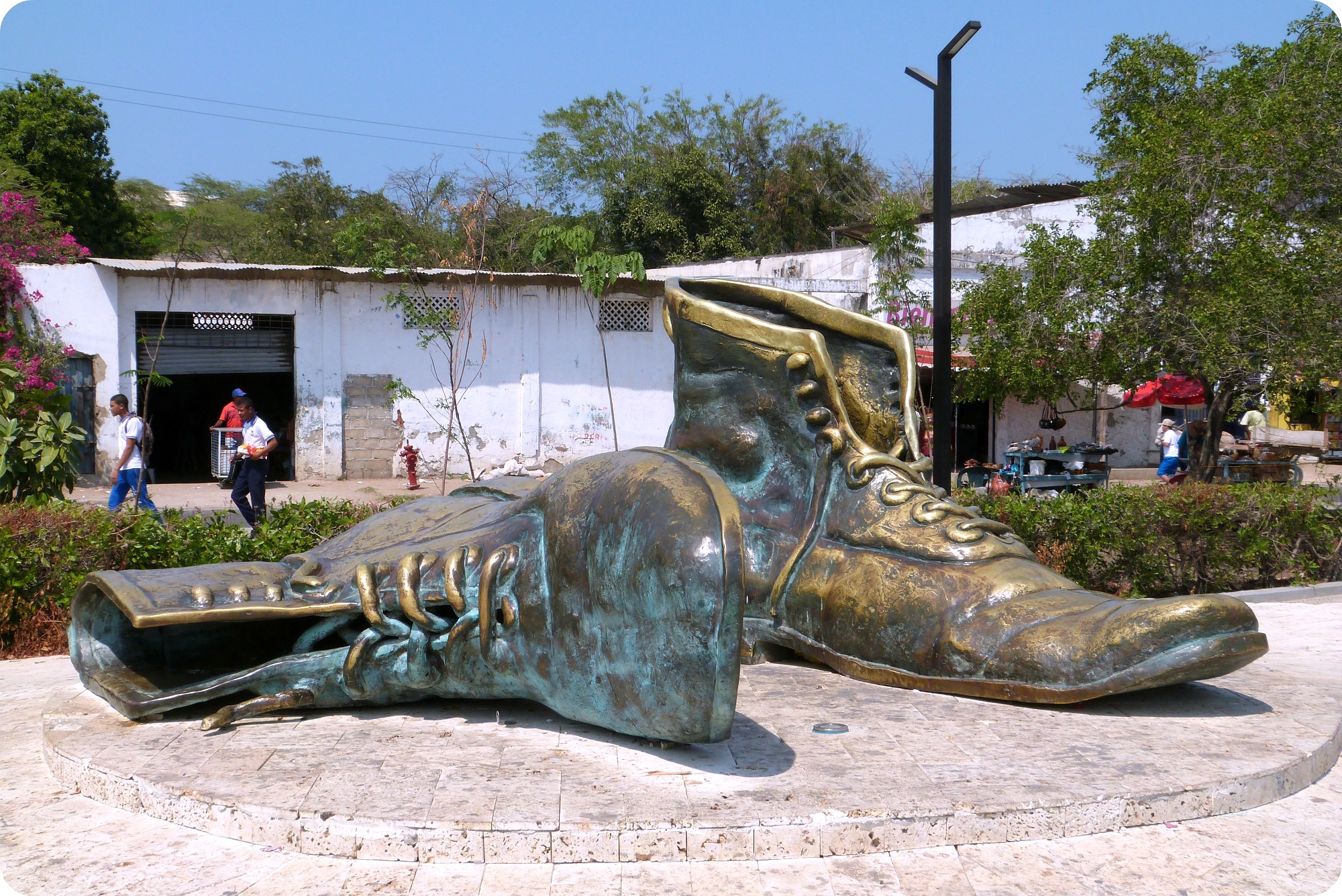 Monumento en bronce de 2 gigantes zapatos cuyo uno se echó hacia al lado cerca del castillo San Felipe de Barajas en Cartagena