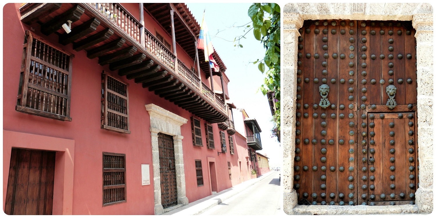 casa roja con una puerta de madera muy imponente llena de enormes clavos y de dos aldabas para tocar en una calle de Cartagena